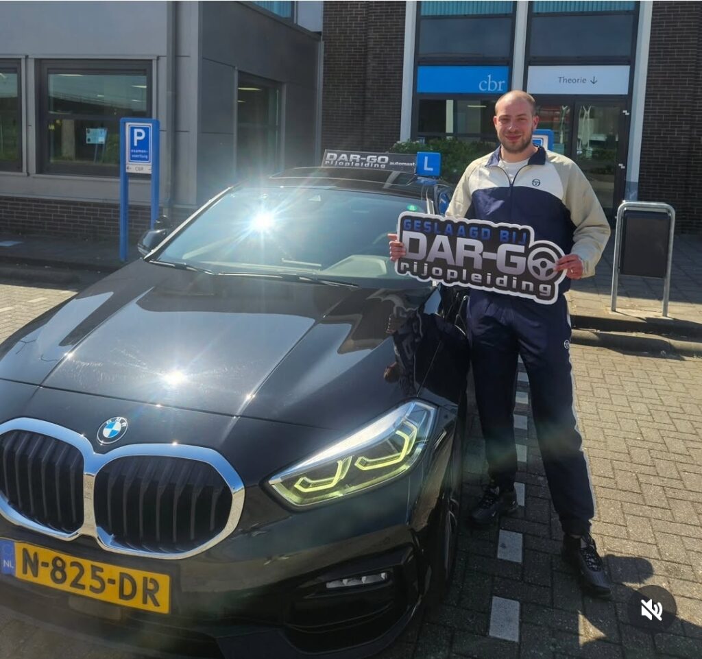 Geslaagde rijleerling van DAR-GO Rijopleiding toont trots zijn behaalde rijbewijs naast BMW lesauto Geslaagde rijleerling van DAR-GO Rijopleiding toont trots zijn behaalde rijbewijs naast BMW lesauto